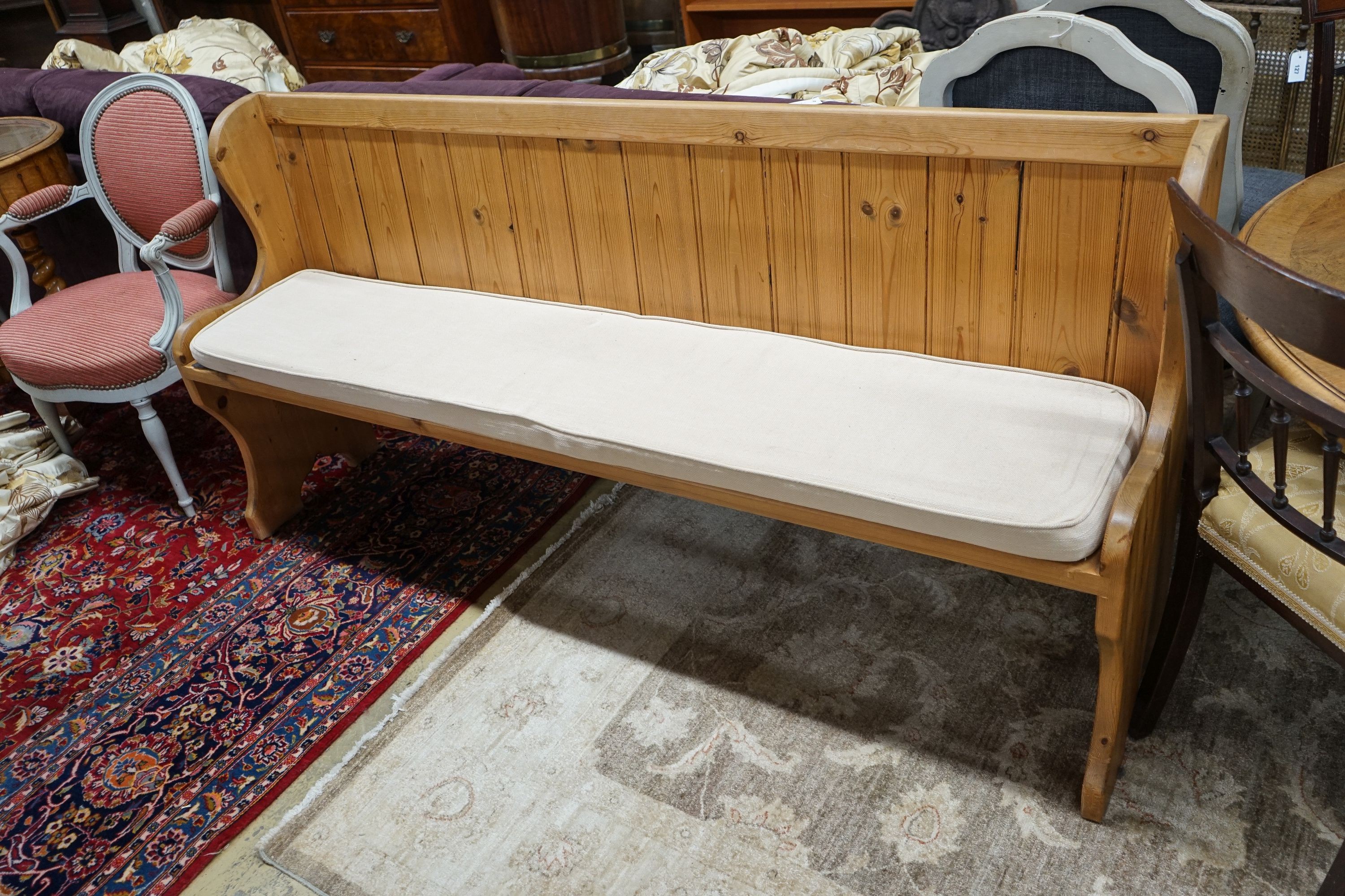 A Victorian style pitch pine pew with cushion seat, length 187cm, depth 40cm, height 88cm